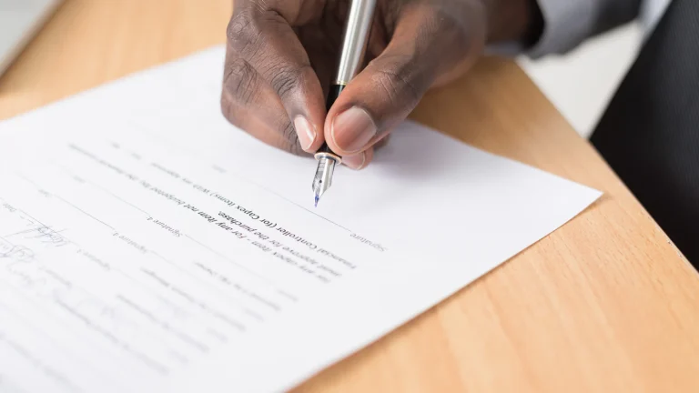 Person carefully reviewing a contract before signing